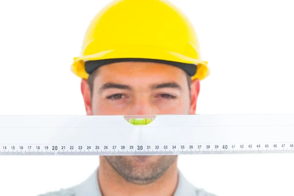 Handyman looking at spirit level — Stock Photo, Image