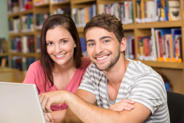 College students using laptop in library — Stock Photo, Image