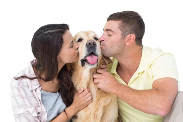 Casal com olhos fechados beijando cão — Fotografia de Stock