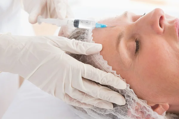 Vrouw ontvangen botox injectie op voorhoofd — Stockfoto