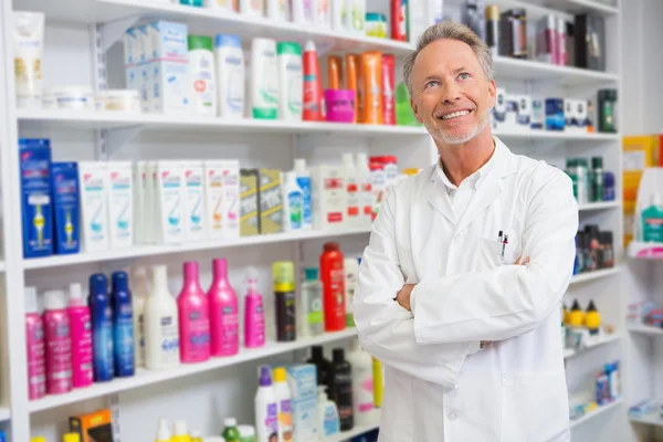 Senior-Apotheker lächelt und blickt auf — Stockfoto