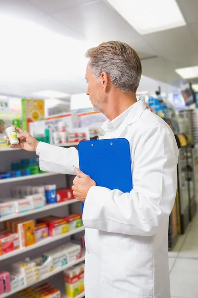 Senior pharmacist reading medicine — Stock Photo, Image