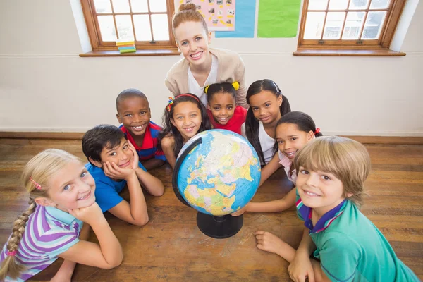 Lindos alumnos y profesor en el aula con globo —  Fotos de Stock