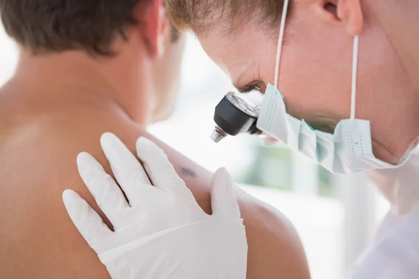 Doctor examining spot at his patient — Stock Photo, Image