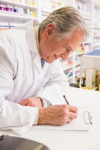 Lachende senior schrijven op Klembord — Stockfoto