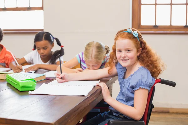 Aranyos tanulók írás osztályban pultnál — Stock Fotó