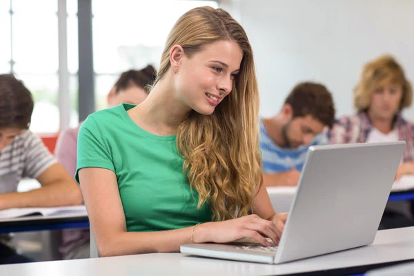 Kvinnlig student med laptop i klassrummet — Stockfoto