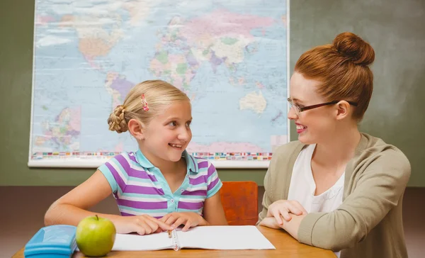 Lehrerin unterstützt Mädchen bei Hausaufgaben im Klassenzimmer — Stockfoto