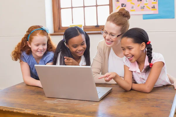 Leraar en leerlingen kijken naar laptop — Stockfoto