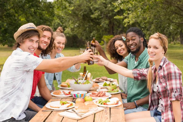 Glückliche Freunde im Park beim Mittagessen — Stockfoto