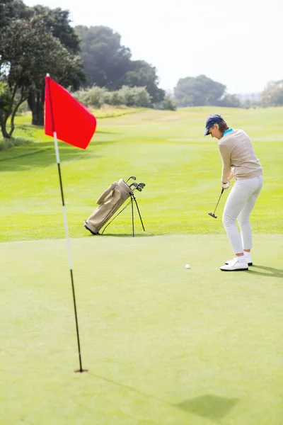 Female golfer putting her ball — Stock Photo, Image