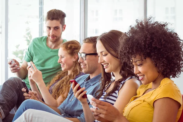 Estudiantes de moda mirando su smatphone — Foto de Stock