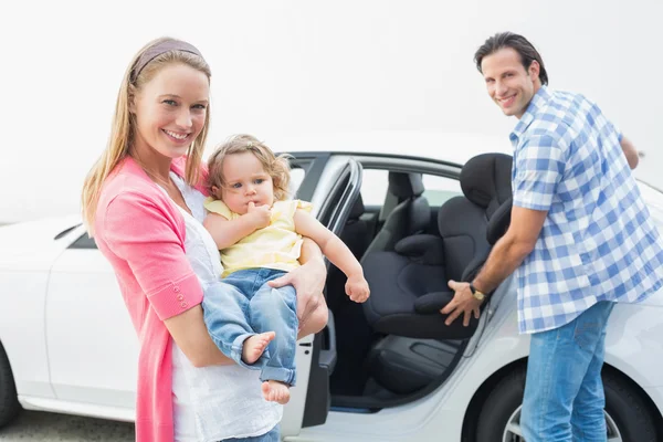 Pais carregando bebê e seu assento de carro — Fotografia de Stock