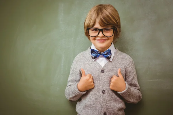 Ragazzino gesticolando pollici contro lavagna — Foto Stock