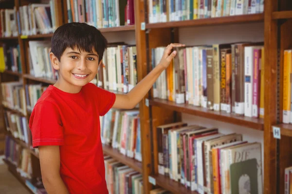 Portrait of boy selecting book in library — Stock Photo, Image