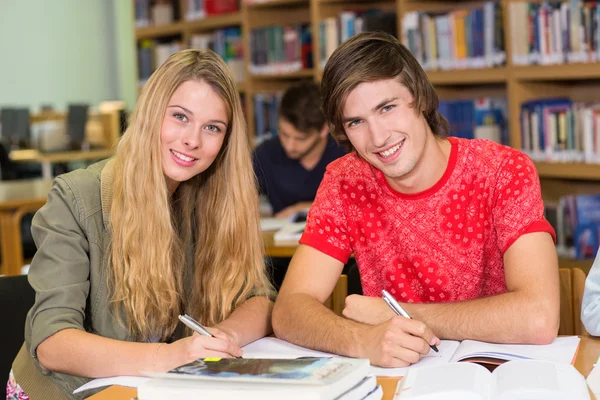 Estudiantes universitarios haciendo deberes en la biblioteca —  Fotos de Stock