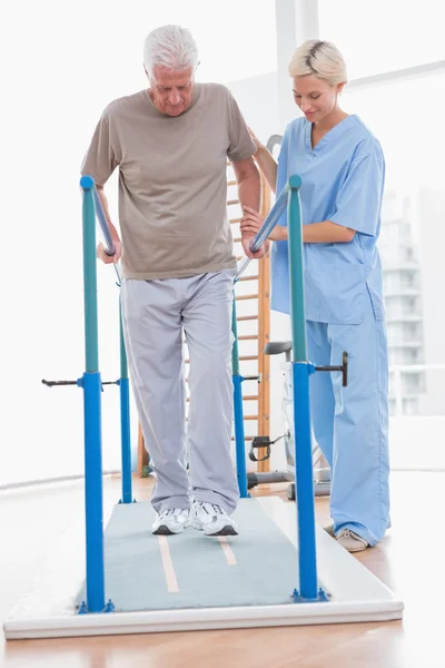 Senior man walking with therapist help — Stock Photo, Image