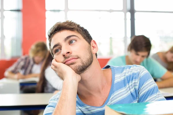 Doordachte student met boeken in klas — Stockfoto