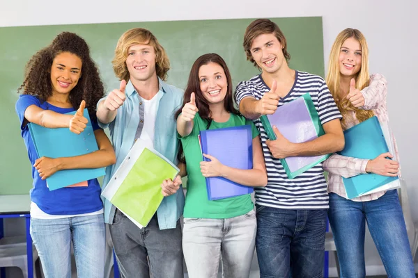 Felice studenti universitari gesticolando pollici in su — Foto Stock