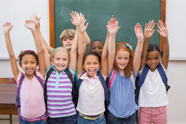 Cute pupils smiling at camera in classroom — Stock Photo, Image