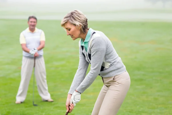 Lady golfista guardato da partner — Foto Stock