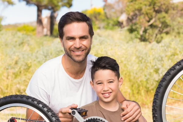 Pai e filho reparando bicicleta juntos — Fotografia de Stock