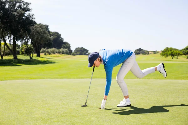 Une golfeuse ramasse une balle de golf — Photo