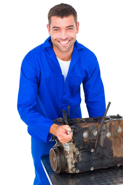 Улыбающийся мужчина чинит двигатель машины — стоковое фото