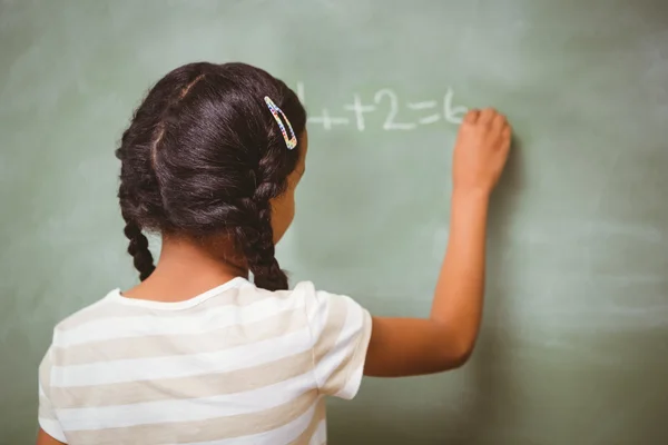 Vista trasera de niña escribiendo en pizarra — Foto de Stock