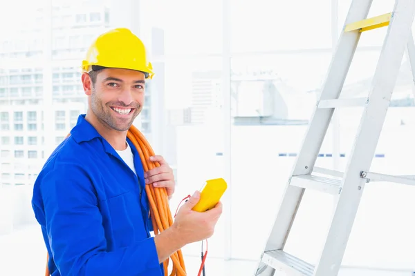 Elektricien bedrijf multimeter in office — Stockfoto