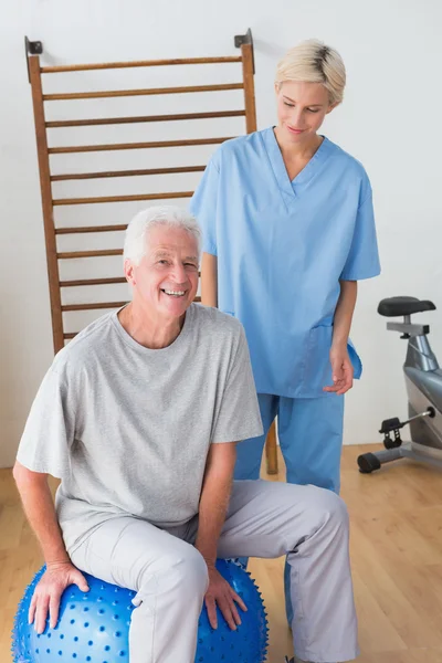 Улыбающийся пожилой мужчина со своим терапевтом — стоковое фото