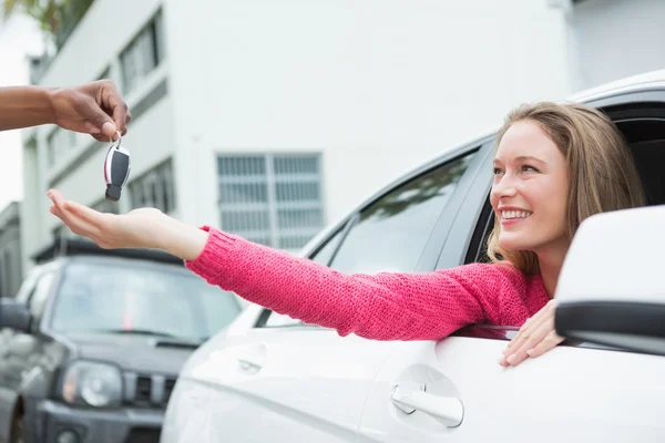 Mujer joven consiguiendo su nueva llave del coche — Foto de Stock