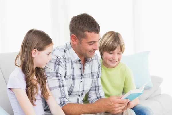 Homme racontant l'histoire aux enfants assis sur le canapé — Photo