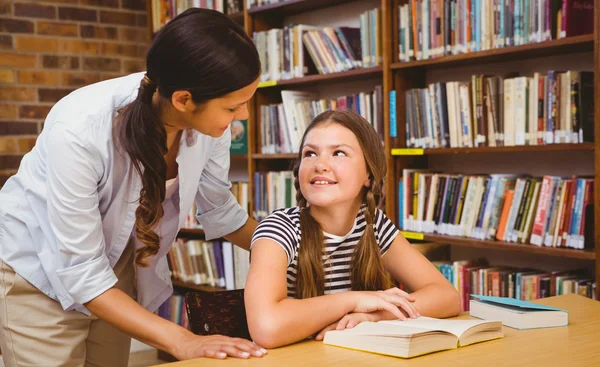 Vrouwelijke leraar en meisje in bibliotheek — Stockfoto