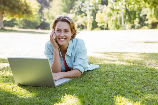 Pretty woman using laptop in park — Stock Photo, Image