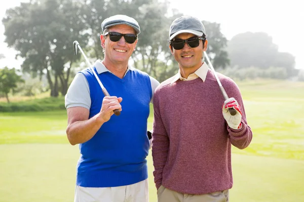 Golfing amigos sonriendo a la cámara celebración de clubes —  Fotos de Stock