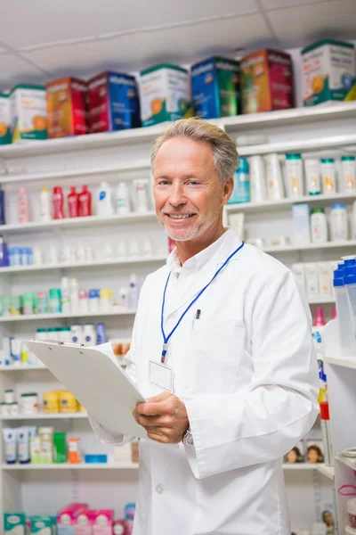 Farmacéutico senior escribiendo en portapapeles —  Fotos de Stock