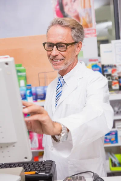 Smiling pharmacist using the computer — Stock Photo, Image