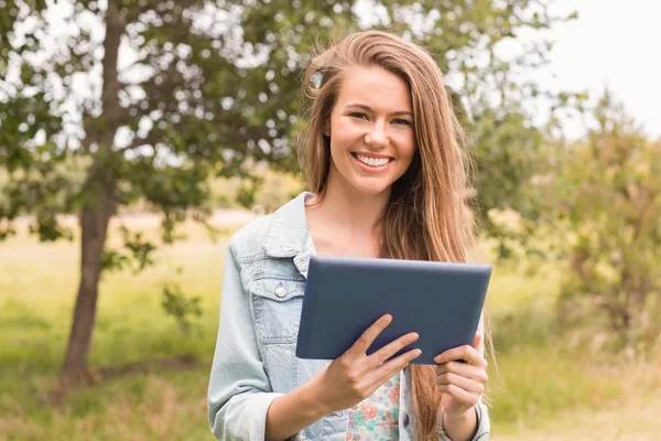 Szczęśliwa młoda kobieta przy użyciu komputera typu tablet — Zdjęcie stockowe