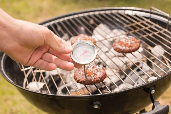 Człowiek za pomocą mięso termometr przy grillu — Zdjęcie stockowe