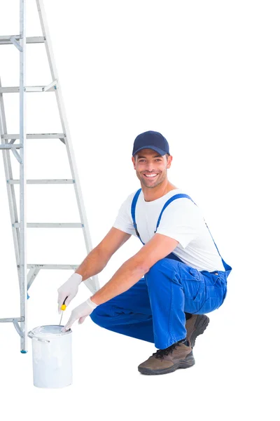 Handyman in overalls opening paint can — Stock Photo, Image