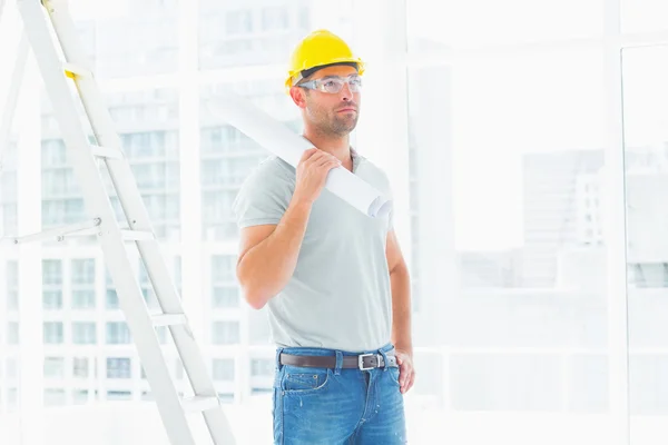 Handyman holding rolled up — Stock Photo, Image