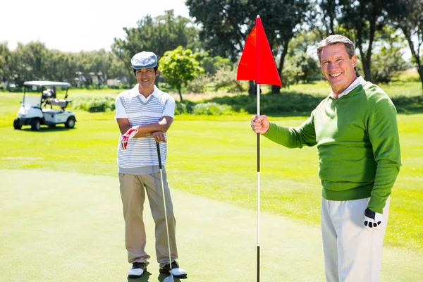 Golfing friends smiling at camera — Stock Photo, Image