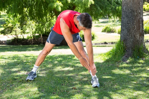 Hombre en forma estirándose en el parque —  Fotos de Stock