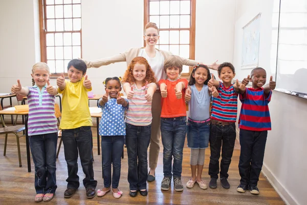 Leraar en leerlingen glimlachen op camera in klas — Stockfoto