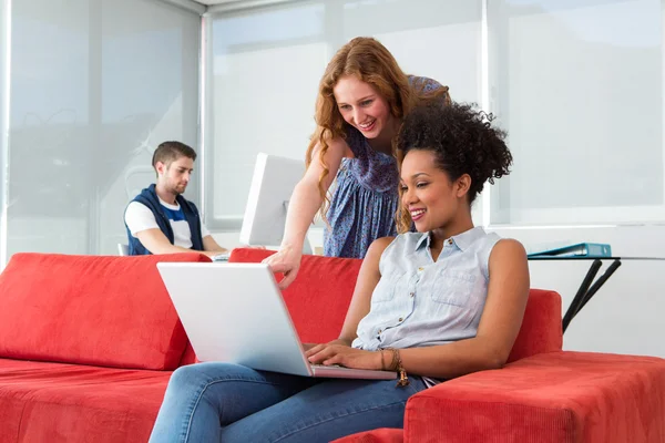 Creative team using laptop on sofa — Stock Photo, Image