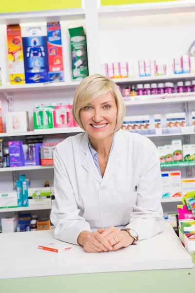 Farmacista sorridente in posa dietro il bancone — Foto Stock