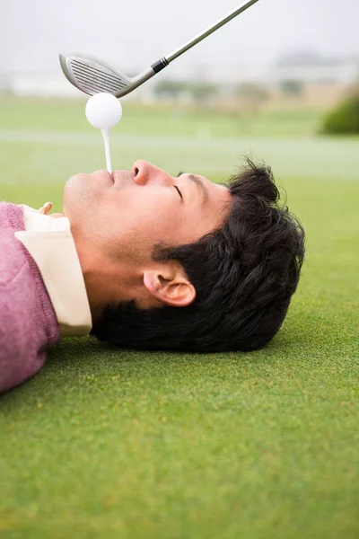 Golfer teeing off from lying man mouth — Stock Photo, Image