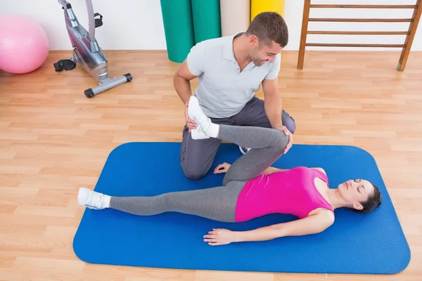 Formateur travaillant avec une femme sur un tapis d'exercice — Photo