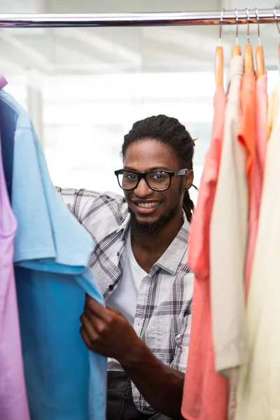 Mężczyzna projektant mody, patrząc w szafie ubrania — Zdjęcie stockowe